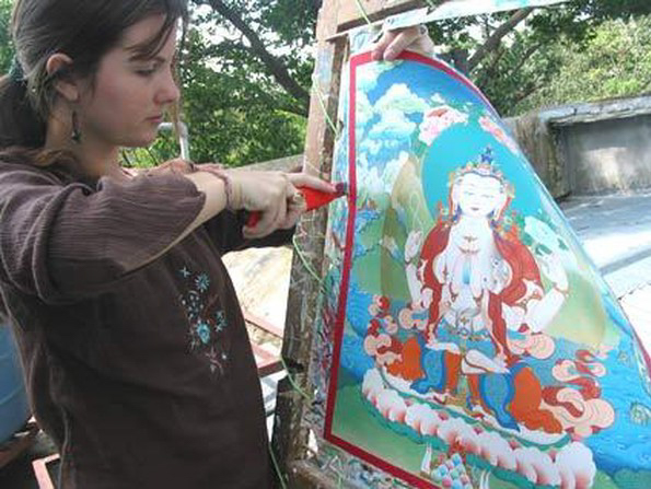 Tiffani Gyatso, a member of the Dakini As Art collective, cuts her completed thangka painting from its stretcher frame. Next it will be framed in brocade. See more of Tiffani's artwork at tiffanigyatso.com.