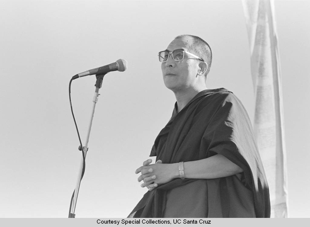 Dalai_Lama_visits_UC_Santa_Cruz_October_1979_the_Dalai_Lama_at_the_microphone_at_the_stage_on_the_East_Field